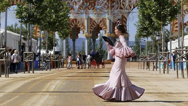 Una joven vestida de gitana pasea por la Feria de Córdoba