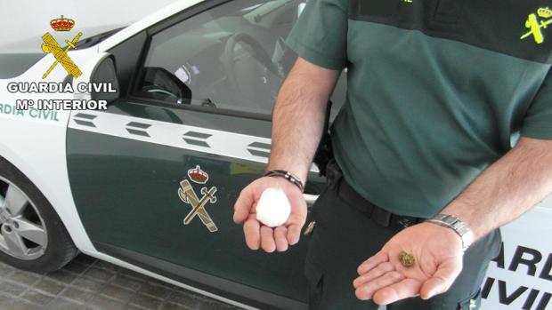 Una agente muestra la pelota de cocaína que llevaban los detenidos