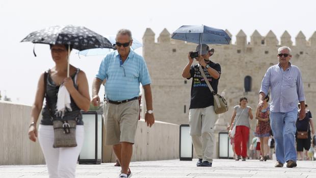 Personas con sombrillas para combatir el calor en Córdoba