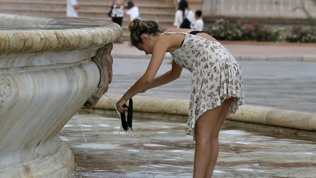 Una chica se refresca en la plaza de España