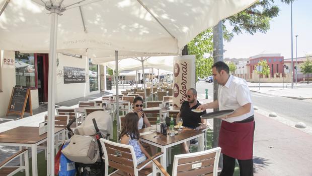 Un camarero atiende una mesa en un bar de la capital