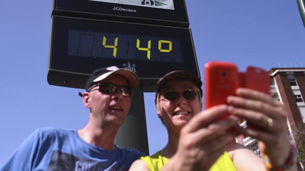 Dos turistas se hacen un «selfie» frente a un termómetro en Córdoba