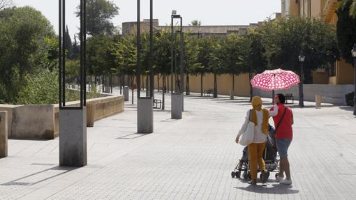 Dos personas se protegen del sol en la zona de la Puerta del Puente de Córdoba