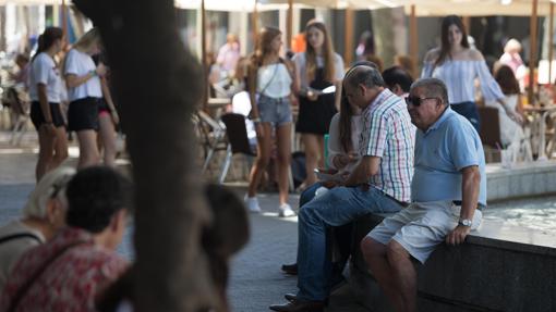 Un grupo de personas en una zona sombreada de Córdoba