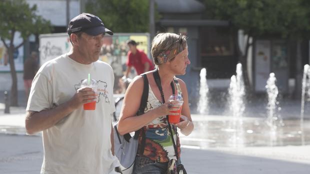 Unos turistas mitigan el calor con unas bebidas frías