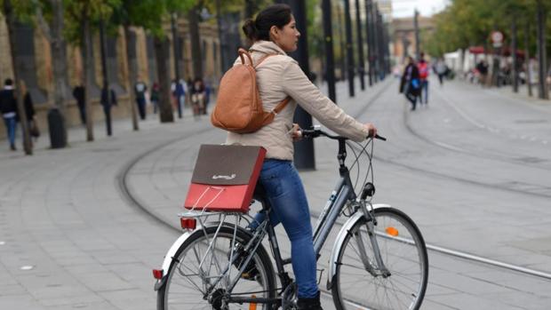 Una mujer acude al trabajo en bicicleta en Sevilla