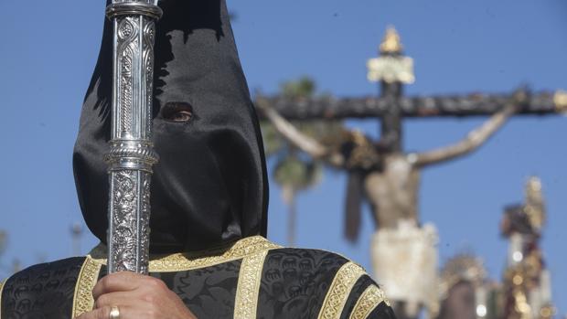 Nazareno del Cristo de Gracia con el paso del Crucificado al fondo