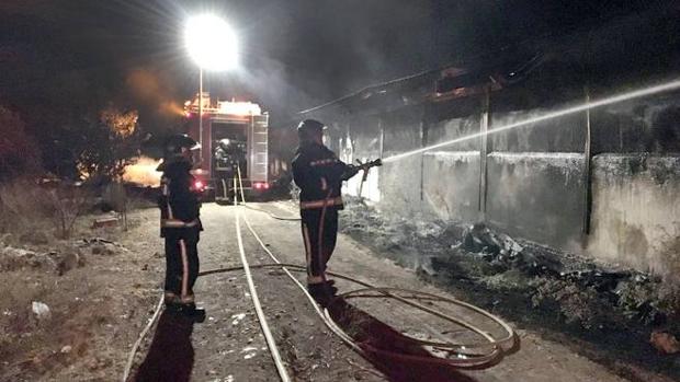 Los bomberos trabajan en la granja calcinada