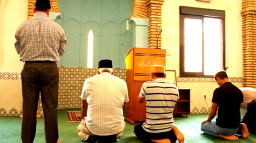 Un grupo de fieles ahmadíes, postrados en dirección a La Meca, orando en el interior de la mezquita