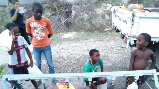 Niños bebiendo en una de las instalaciones montadas por Bomberos sin Fronteras