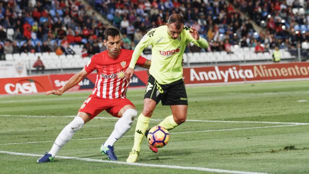 Un momento del partido entre el Córdoba CF y el Almería, Juli presionado por Trujillo