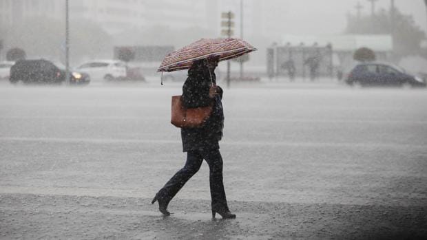 Una señora camina bajo una intensa lluvia en el centro de Córdoba