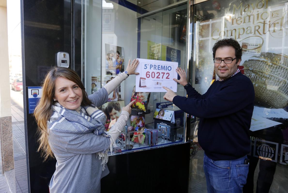 Los loteros de «El Califa de la suerte» muestran el número del décimo premiado en Córdoba