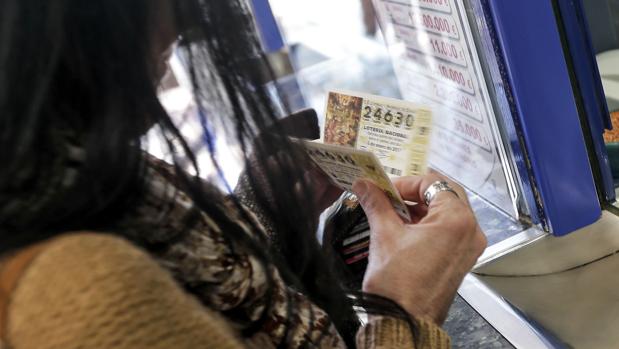 Una mujer mira un décimo del sorteo de «El Niño»