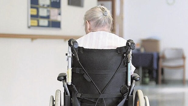 Una anciana, en silla de ruedas