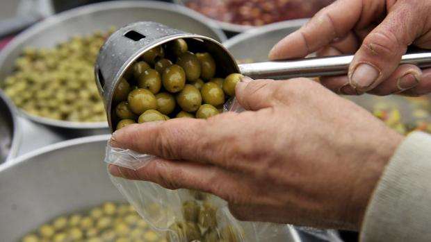 Un hombre sirve una bolsa de aceituna de mesa