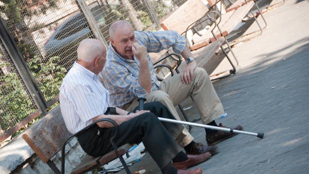 Dos ancianos conversan en un banco