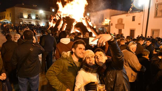 Tres personas se retratan junto a la gran candela de Dos Torres