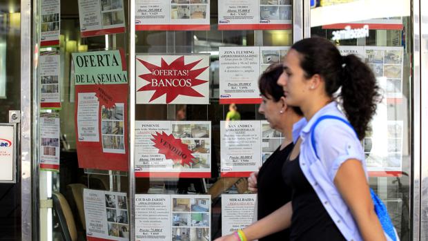 Dos mujeres pasan frente a una inmobilaria