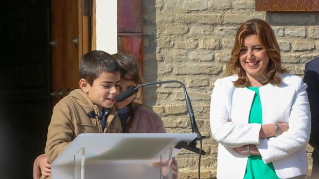 La presidenta Susana Díaz escucha a unos niños lleer párrafos del Estatuto de Autonomía en Coria del Río.