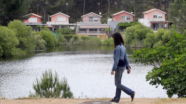 Una joven camina por delante del lago de Las Jaras