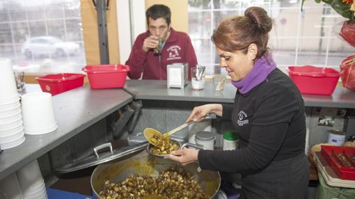 Una mujer sirve un plato de caracoles en uno de los puestos repartidos por Córdoba