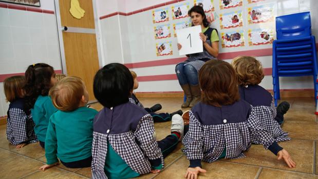 Un grupo de niños atiende a su maestra en una guardería