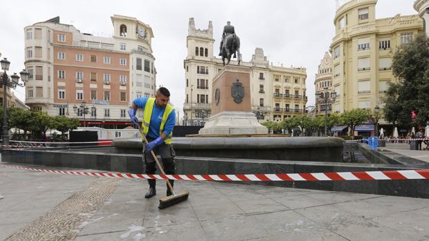 Un operario quita los restos de la espuma que esta mañana ha aparecido en la fuente de Las Tendillas