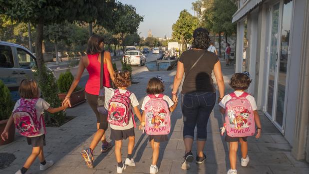 Dos mujeres llevan a cuatro niñas al colegio