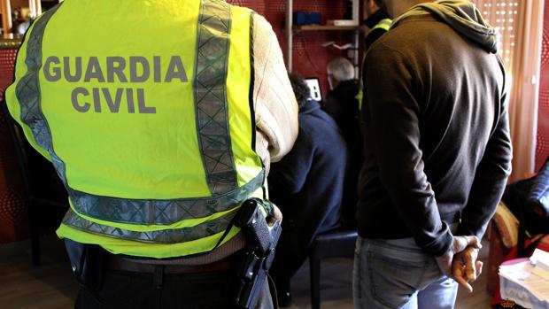 Un agente de la Guardia Civil con un detenido