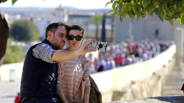 Dos turistas se hacen un «selfie» junto al Puente Romano