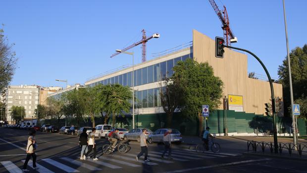 Algunas personas cruzan el paso de peatones cercano a las obras de la Biblioteca del Estado