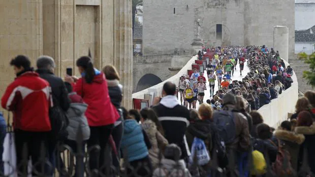 Los corredores encaran la recta final por el Puente Romano durante 2016