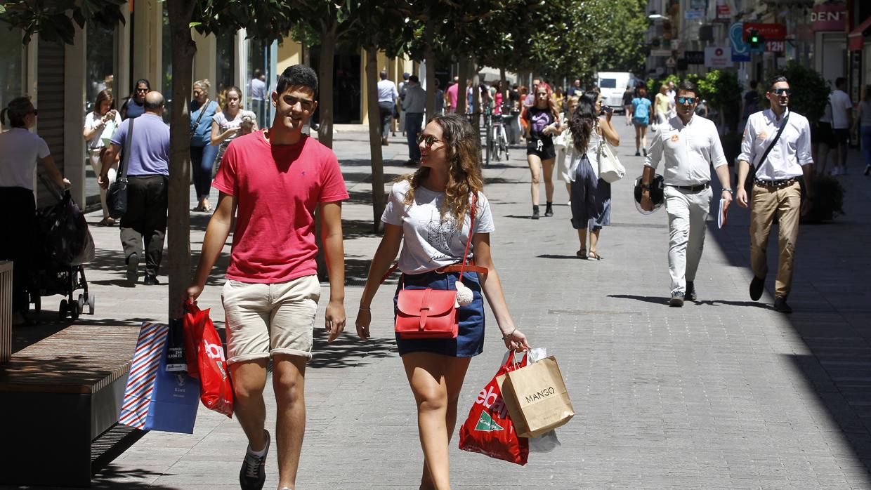 Una pareja pasea por Cruz Conde con bolsas de las rebajas