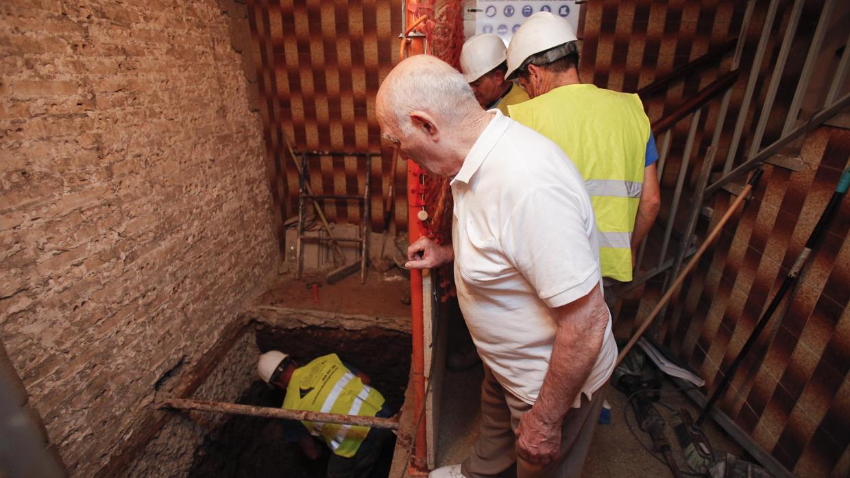 Un vecino observa a los operarios que realizan las obras para instalar el elevador