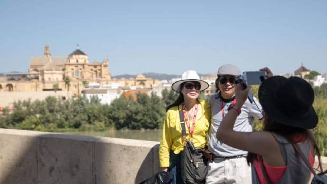 Dos turistas se hacen una fotografía en el Puente Romano