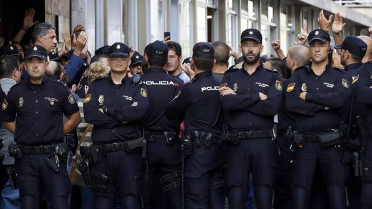 A la izquierda, el lider de los populares en Cataluña, visita a los policías acosados en Barcelona