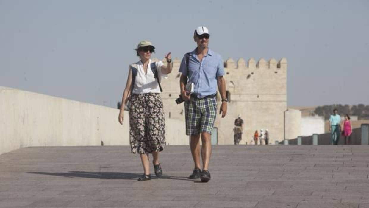 Una pareja de turistas paseando por el Puente Romano