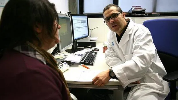 Un médico pasa consulta a una paciente