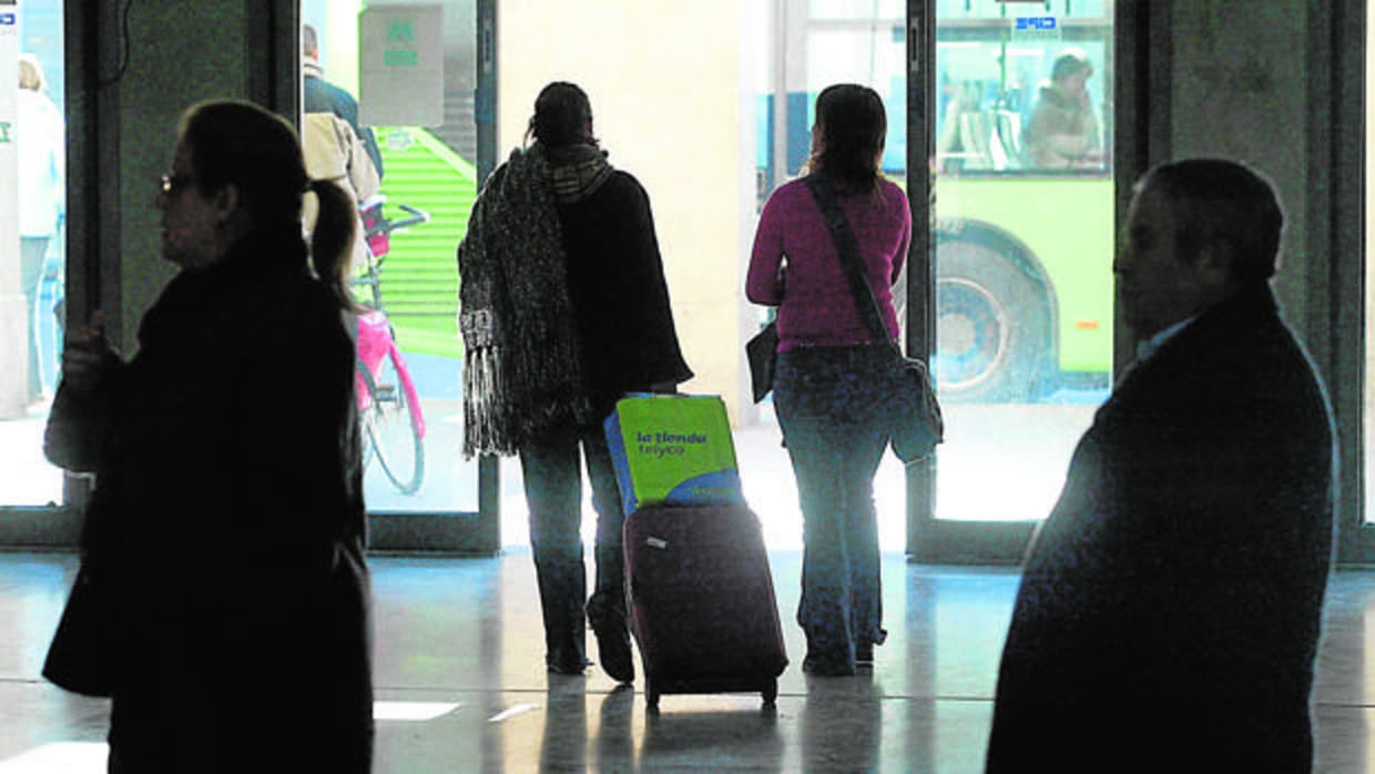 Dos jóvenes con maletas abandonan la estación de autobuses