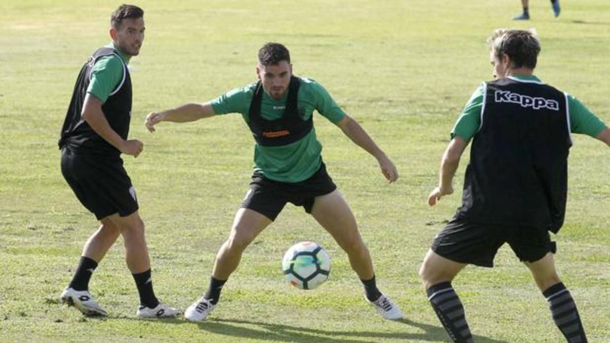 Javi Galán conduce el esférico entre los cordobeses Fernández y Javi Lara