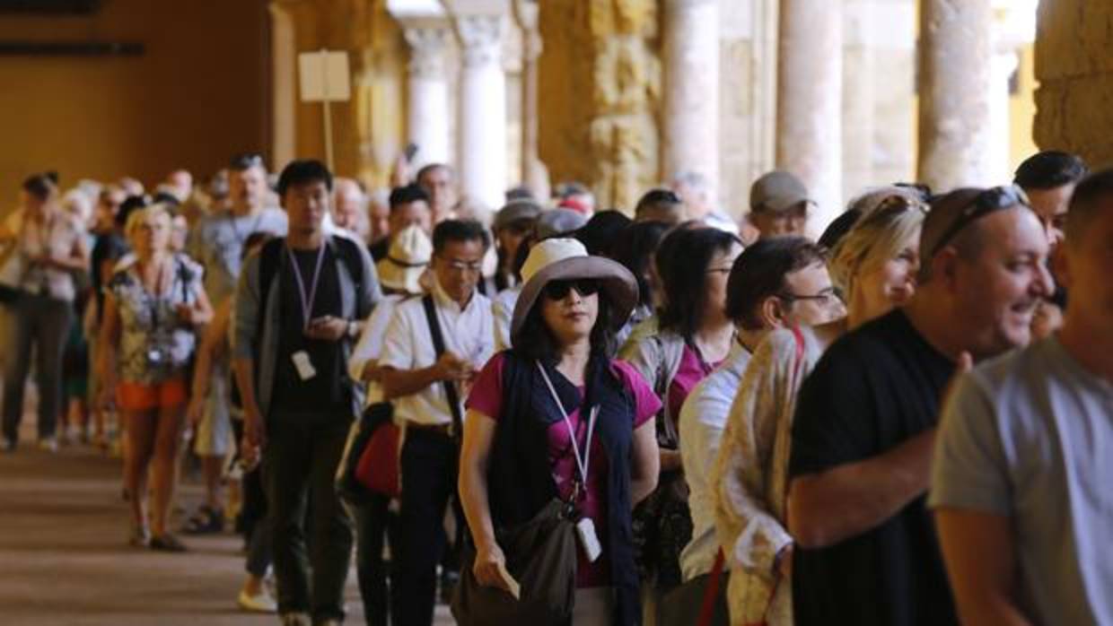 Una cola de turistas extranjeros en las galerías del Patio de los Naranjos de la Mezquita-Catedral de Córdoba