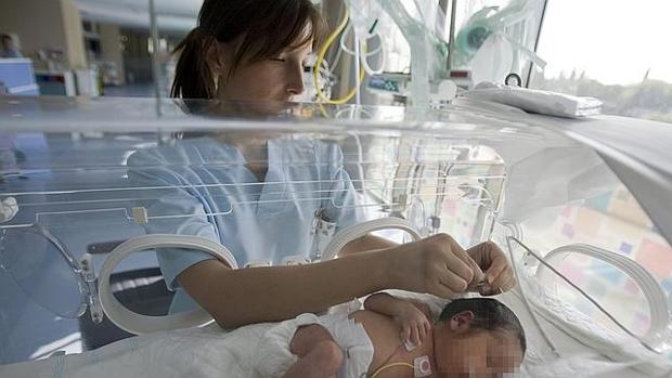 Una enfermera cuidando de un neonato