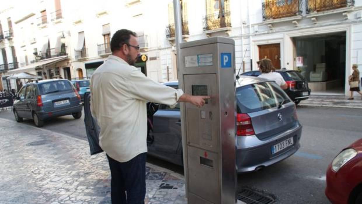 Un hombre extrae un ticket para la zona azul