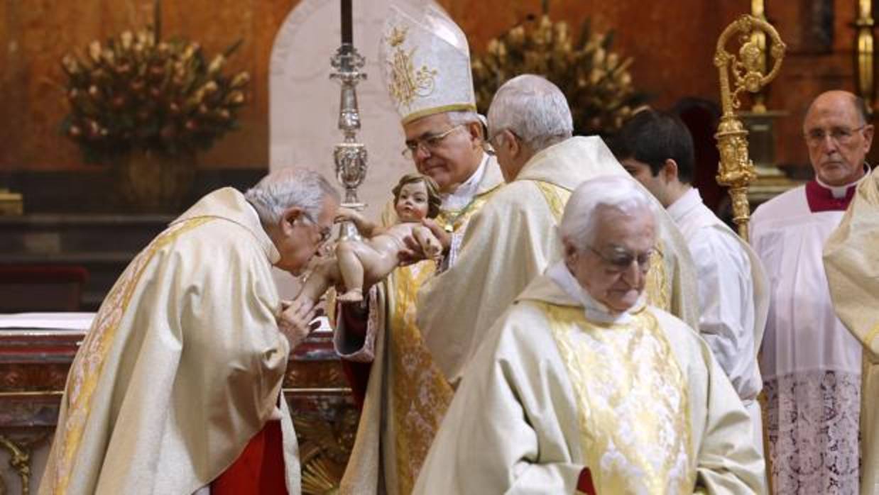 El obispo da a besar la imagen del Niño Jesús en la misa del día de Navidad