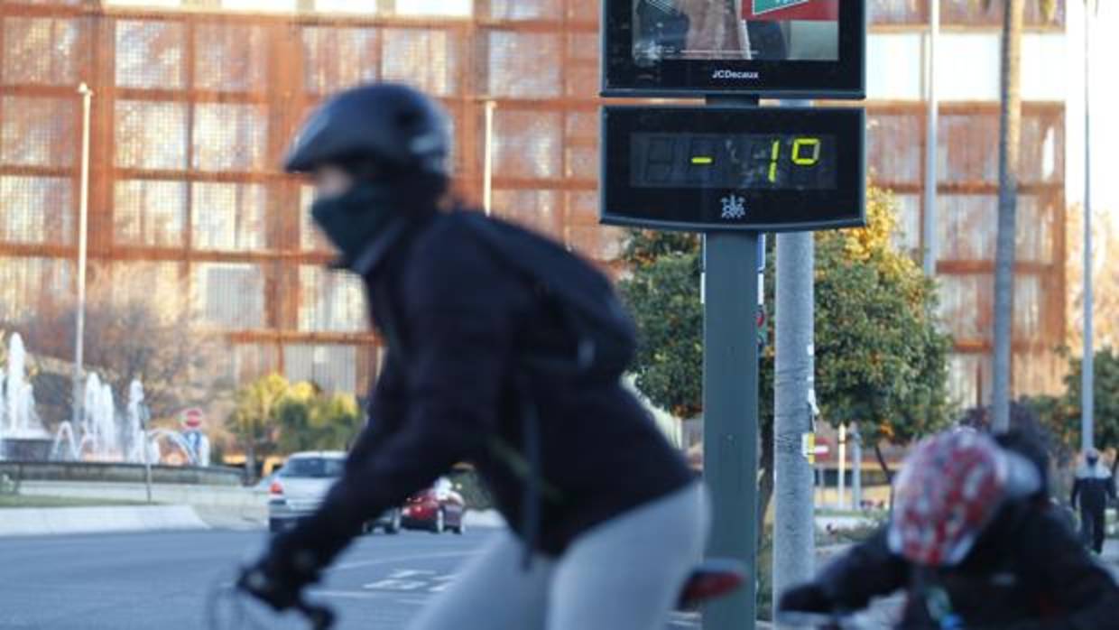 Un ciclista bien abrigado cruza la avenida Vallellano de Córdoba con un termómetro en negativo