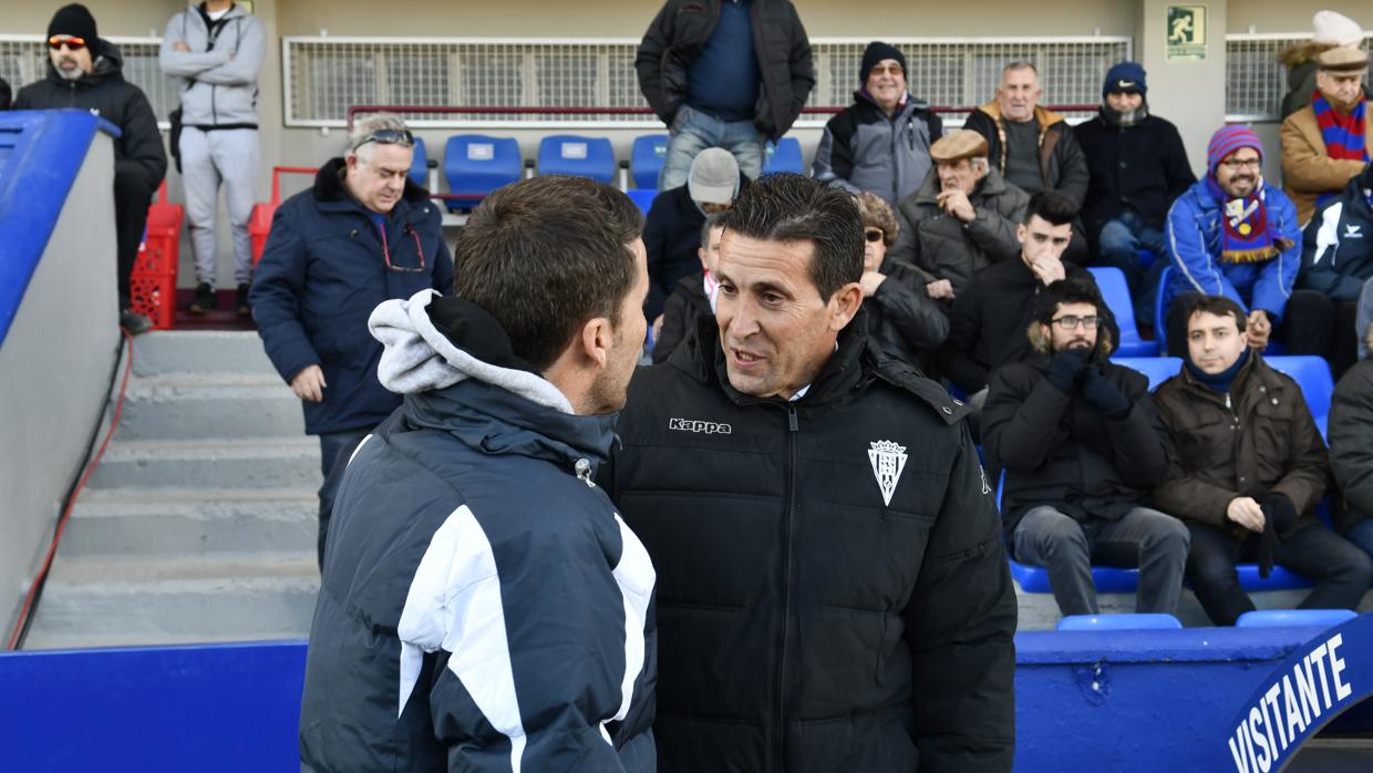 Juan Merino conversa con Rubi antes de empezar el Huesca-Córdoba