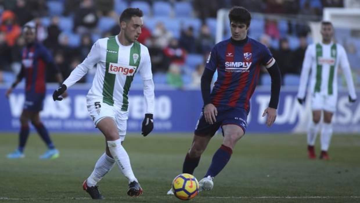 Sergio Aguza conduce la pelota ante Melero, capitán del Huesca