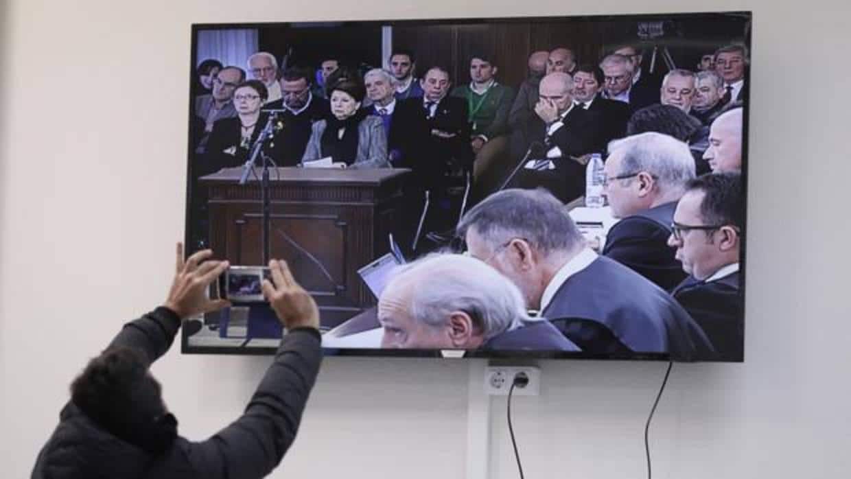 Un periodista toma una imagen del juicio del caso ERE en la pantalla de la sala de Prensa