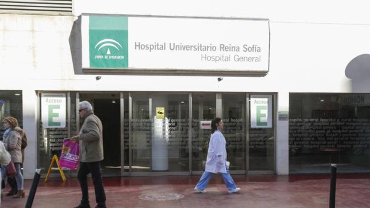 Una profesional sanitaria pasa por delante de la puerta de Consultas Externas del Reina Sofía